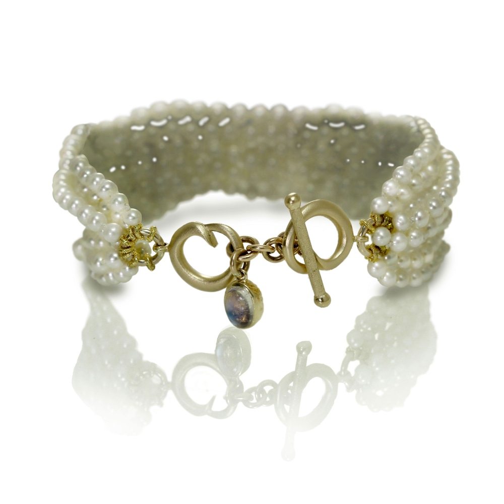Six Strand White Pearl Bead Bracelet with two rose gold celtic spirals and oval Rainbow Moonstone cabouchon charm